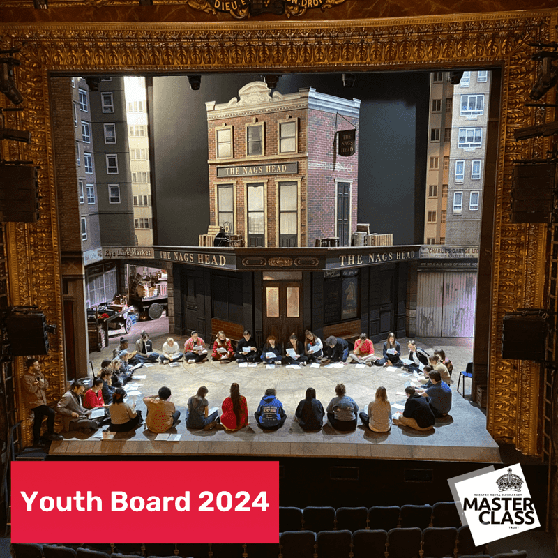 A photo of the Theatre Royal Haymarket stage full of members taking part in a workshop. The set is from Only Fools and Horses. A gold proscenium arch can be seen.