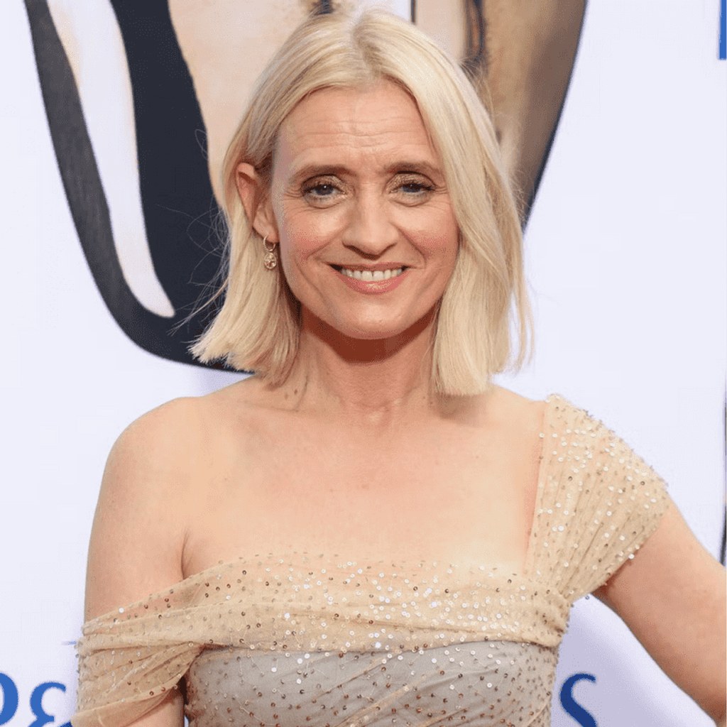Anne-Marie Duff at the BAFTAs. wearing a sparkly champagne coloured dress. Anne-Marie is a white Irish woman who has blonde hair in a bob, with a gold earring and has a teeth showing smile.