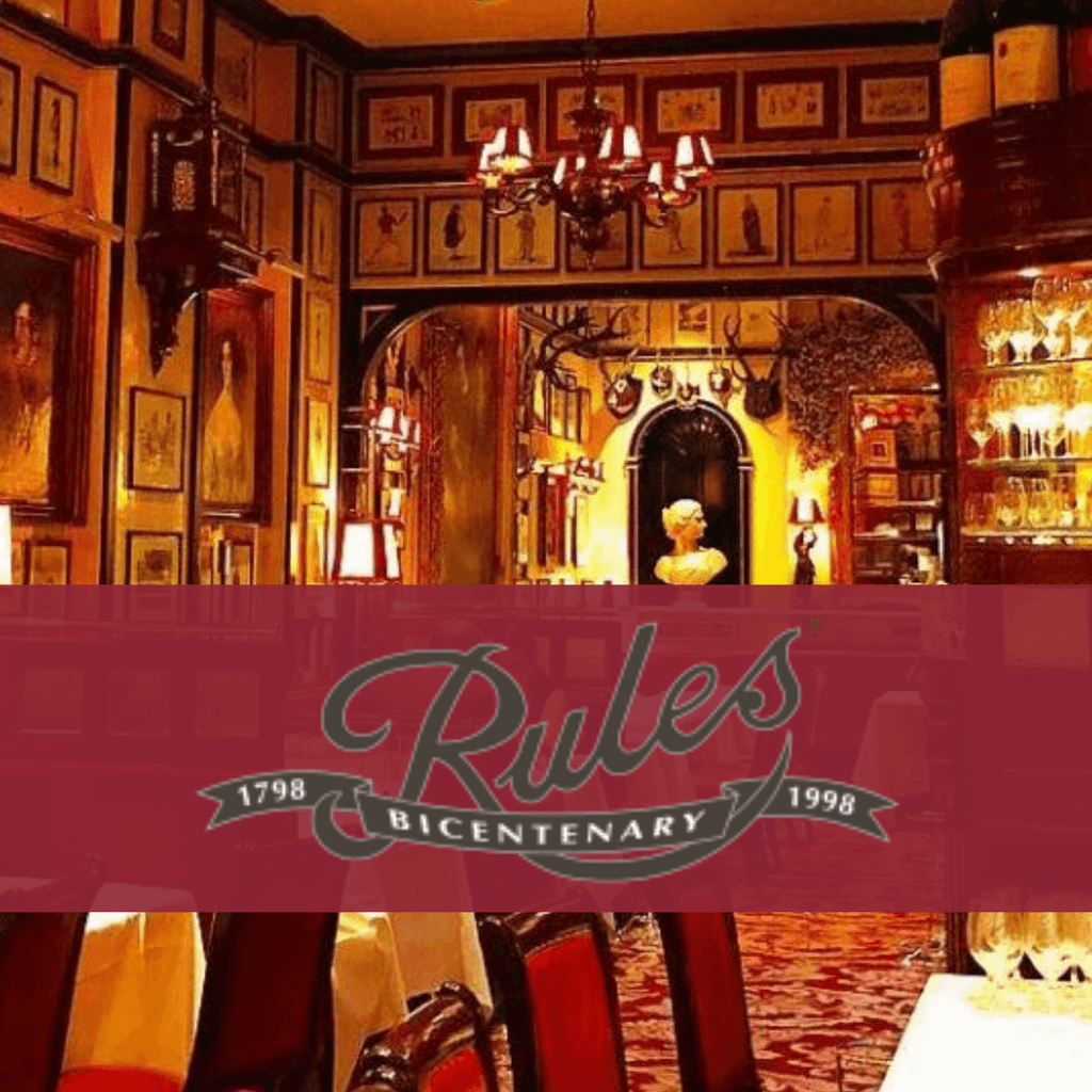 Elegant vintage restaurant interior with chandeliers and framed art on the walls. Rules Restaurant is written in the centre over a red block.